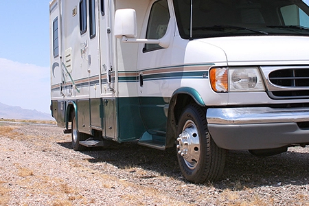 An RV parked with a focus on its tires, illustrating the importance of RV tire insurance.