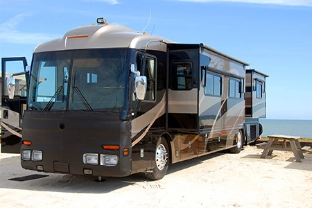 An RV parked with a focus on its tires, illustrating the importance of RV tire insurance.